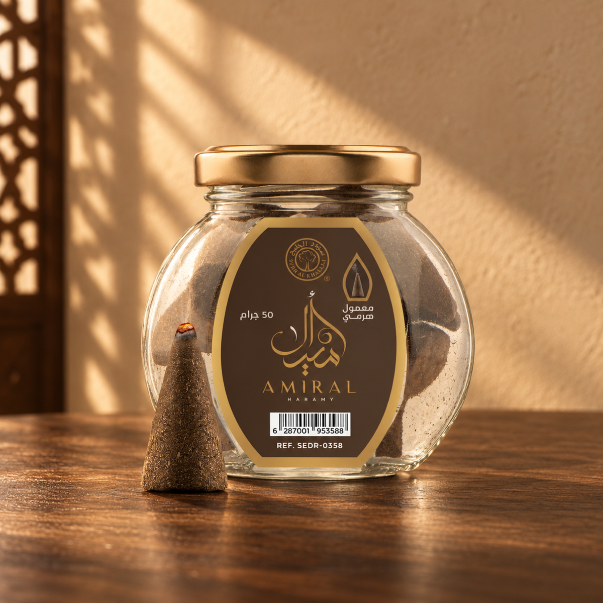 Amiral Pyramid Maamoul 50 g from Sedr Al-Khaleej; round glass incense jar with a brown label, gold lid and one cone on walnut wood in angled sunlight.