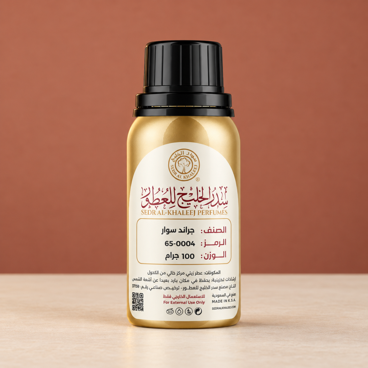 عطر زيتي مستوحى من عطر جراند سوار من سدر الخليج، عبوة ذهبية مغلقة على سيراميك كريمي أمام خلفية طيني وردي