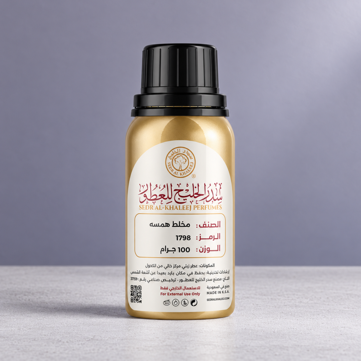 Sedr Al-Khaleej hammsah perfume oil gold bottle on white matte concrete, against plain soft violet-grey wall