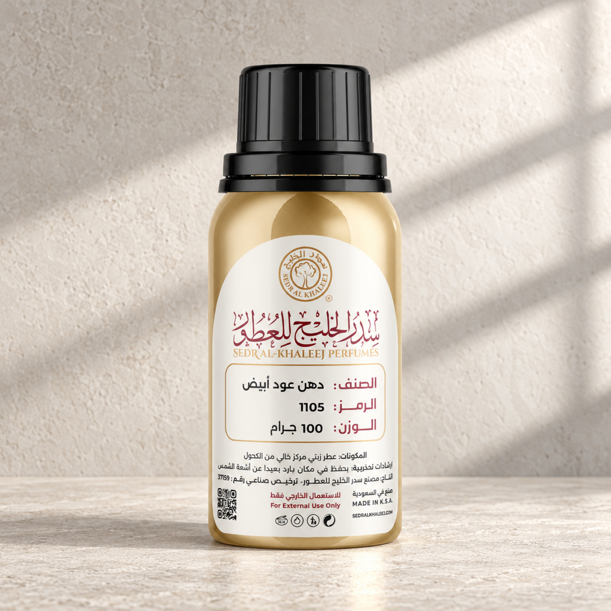 Sedr Al-Khaleej white oud dehen perfume oil; one closed original bottle on honed light ash limestone with subtle mineral grain, against silver-beige plaster wall.