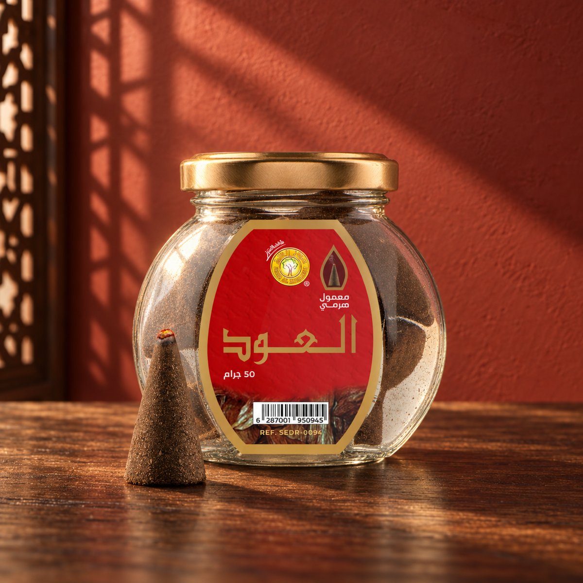 Al Oud Pyramid Maamoul 50 g from Sedr Al-Khaleej; round glass incense jar with a red label, gold lid and one cone on walnut wood in angled sunlight.