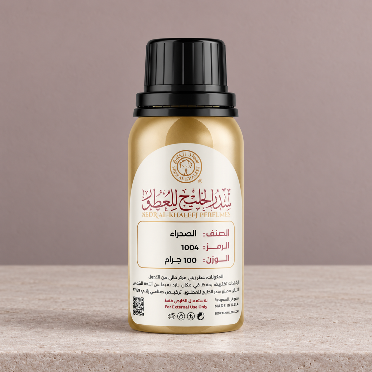 Sedr Al-Khaleej Alsahraa perfume oil, gold bottle on pale sandstone against a dusty rose-grey wall in neutral side light
