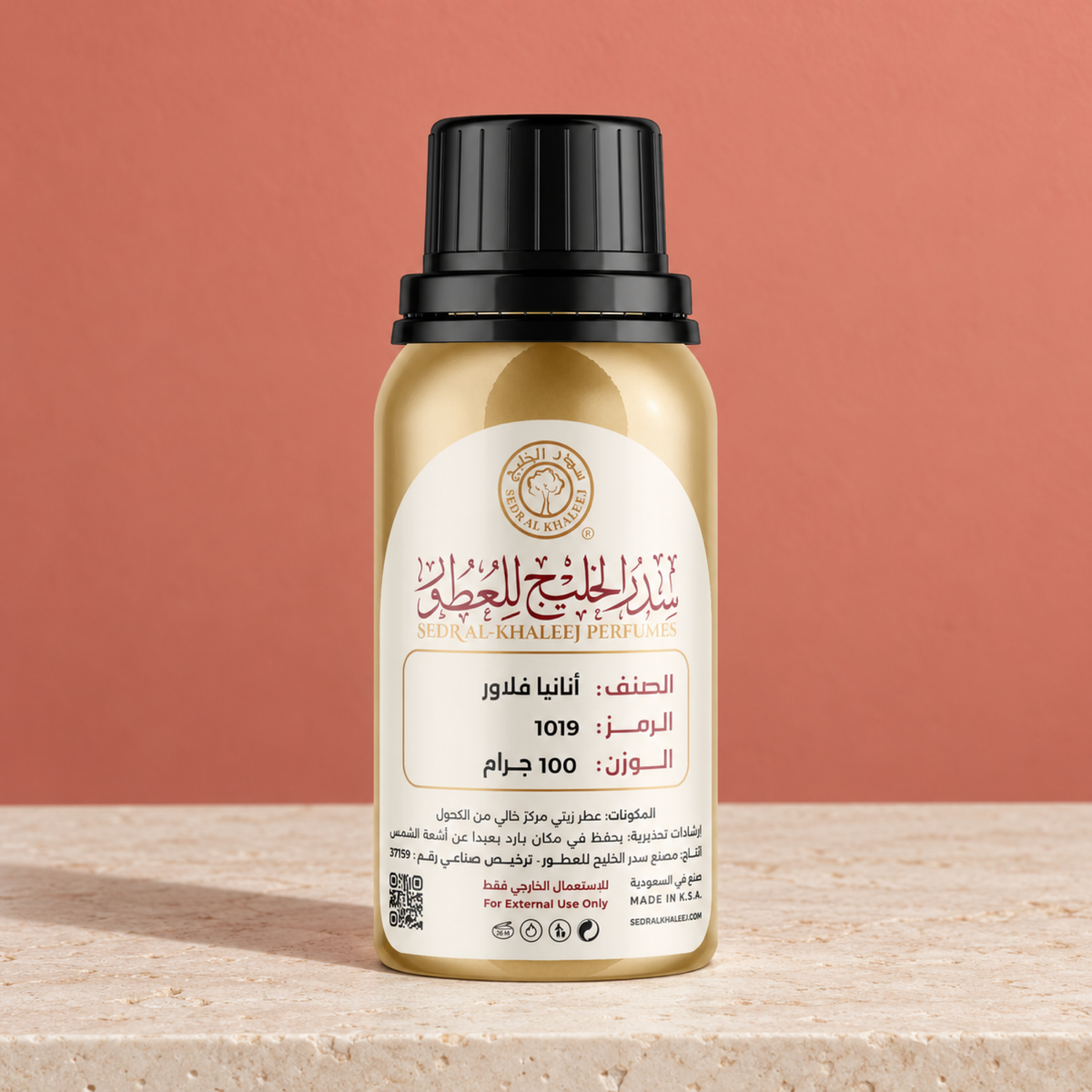 Sedr Al-Khaleej anania flower perfume oil; one closed original bottle on honed ivory limestone, against plain muted-coral wall.