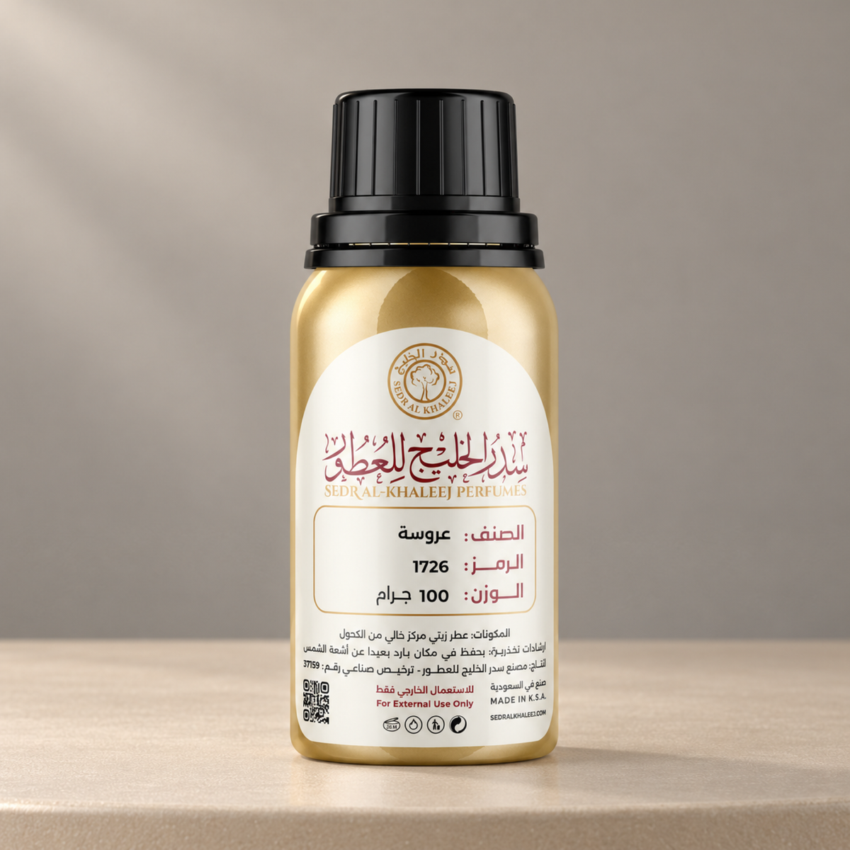 Sedr Al-Khaleej arousah perfume oil; one closed original bottle on matte champagne-beige ceramic, against plain warm dove-grey wall.