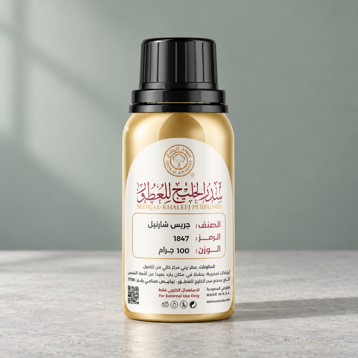 Sedr Al-Khaleej gris charnel perfume oil gold bottle on pale grey limestone, against plain mist-sage wall
