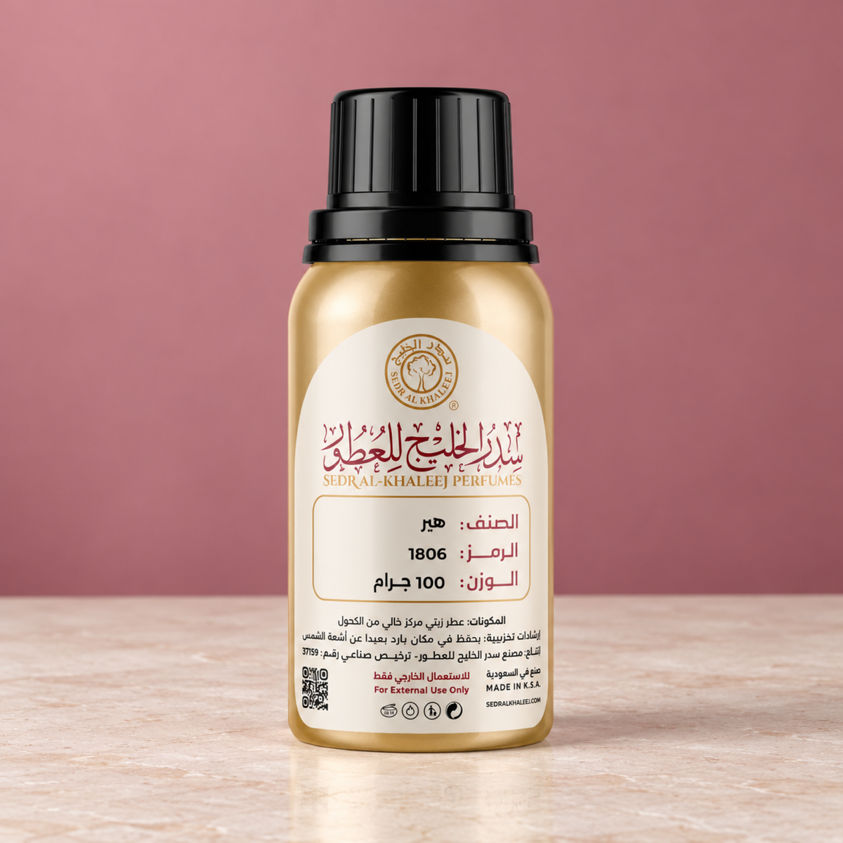 Sedr Al-Khaleej her perfume oil gold bottle on pale ivory mineral resin, against plain muted raspberry-blush sweep