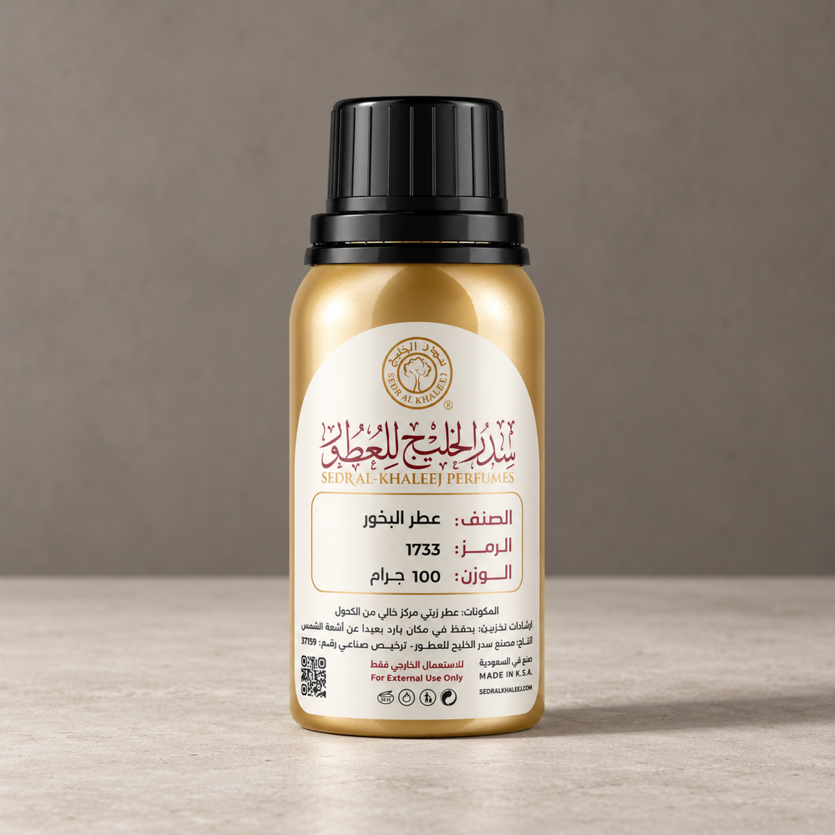 Sedr Al-Khaleej incense fragrance perfume oil gold bottle on matte off-white limestone, against plain smoked clay-grey wall