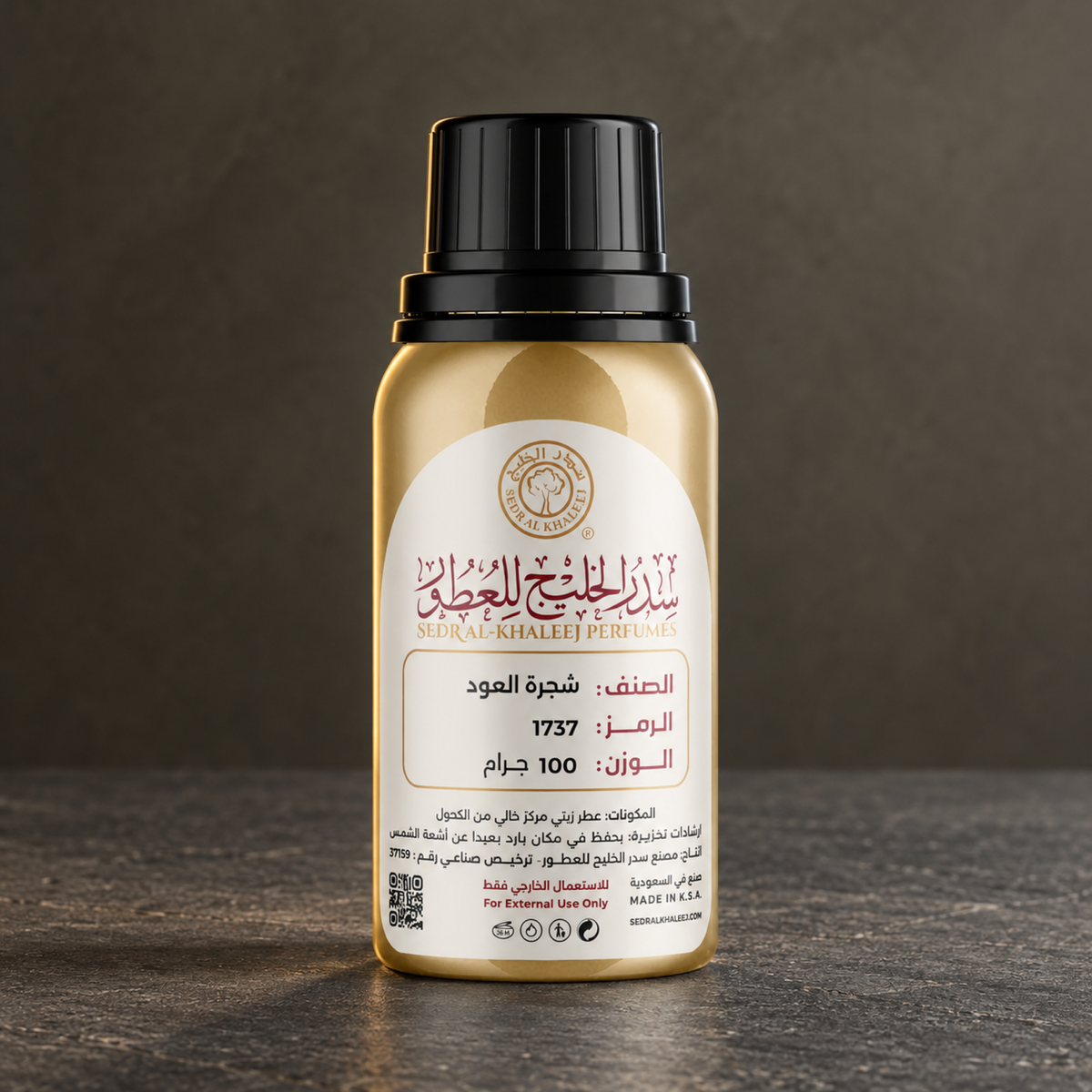 زيت عطري شجرة العود من سدر الخليج؛ حجر رملي داكن وخلفية زيتونية رمادية بضوء جانبي بارد، العبوة الأصلية مغلقة.