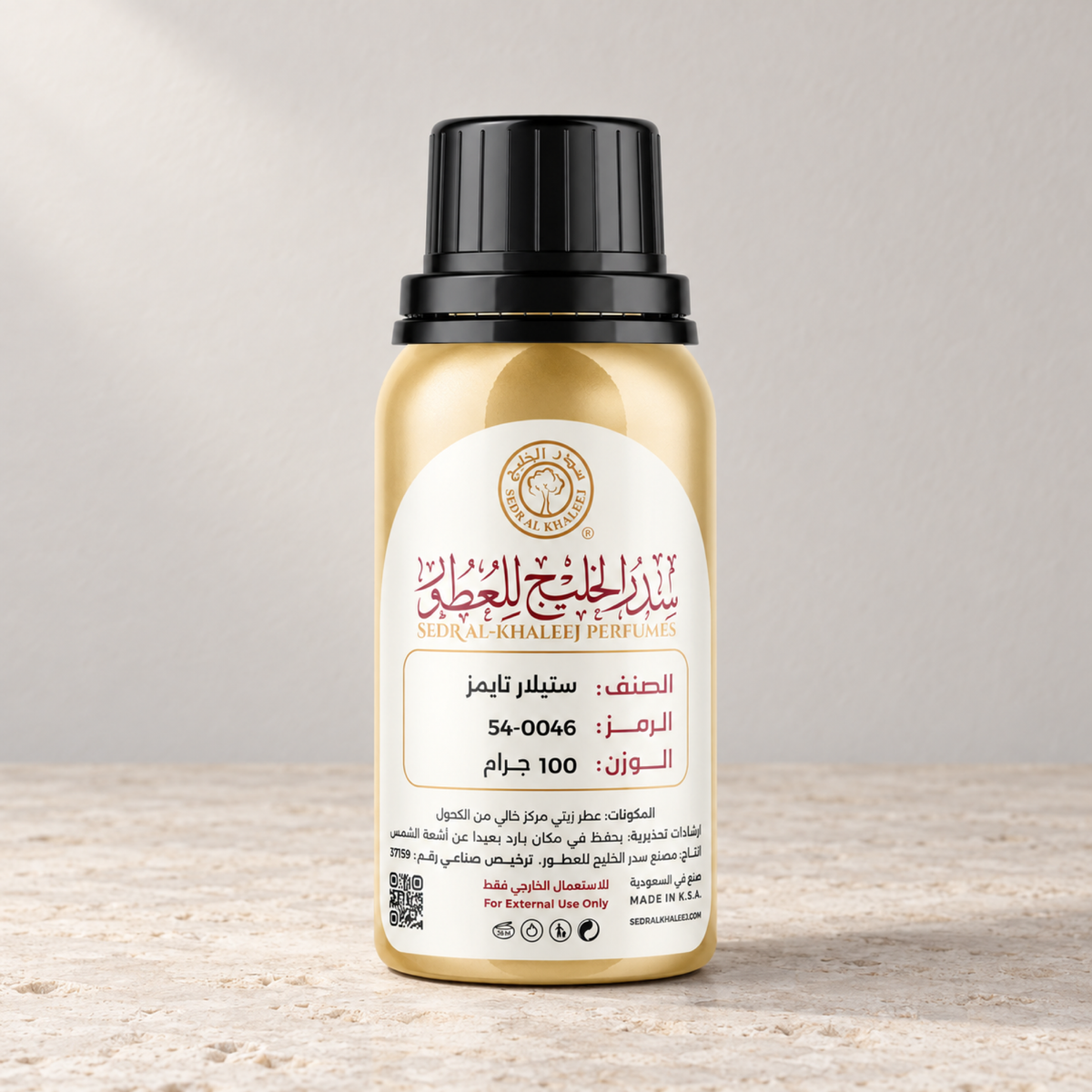 Sedr Al-Khaleej Stellar Times perfume oil; a closed gold bottle on pale limestone before an ivory-grey backdrop in diffuse light.