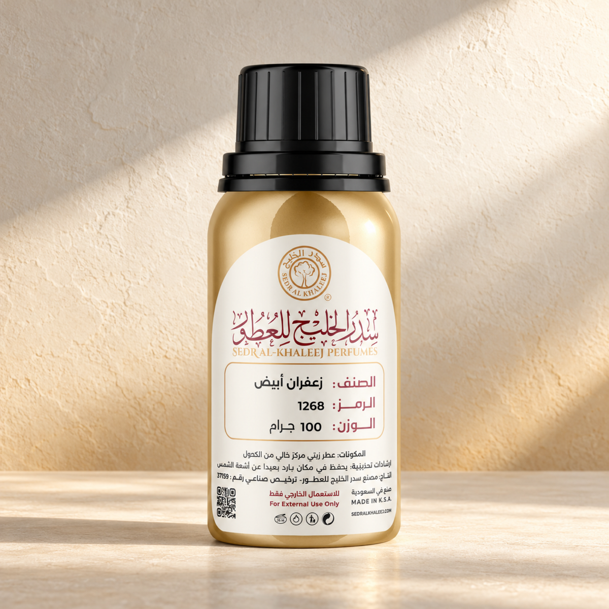 زيت عطري زعفران أبيض من سدر الخليج؛ عبوة أصلية مغلقة على خزف كريمي وخلفية طباشيرية بلمسة مغرة خافتة وضوء دافئ ناعم.